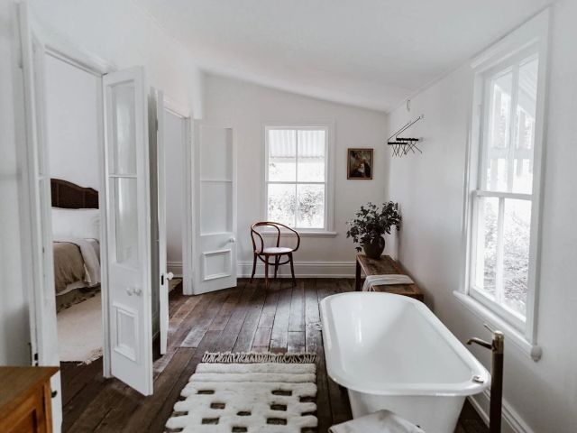 the whitewashed interior of The Postman’s Cottage with a private tub