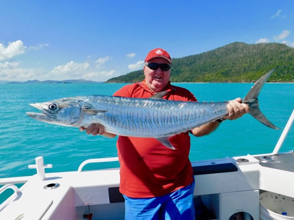 a man holding a huge fish, Airlie Beach Fishing Charters