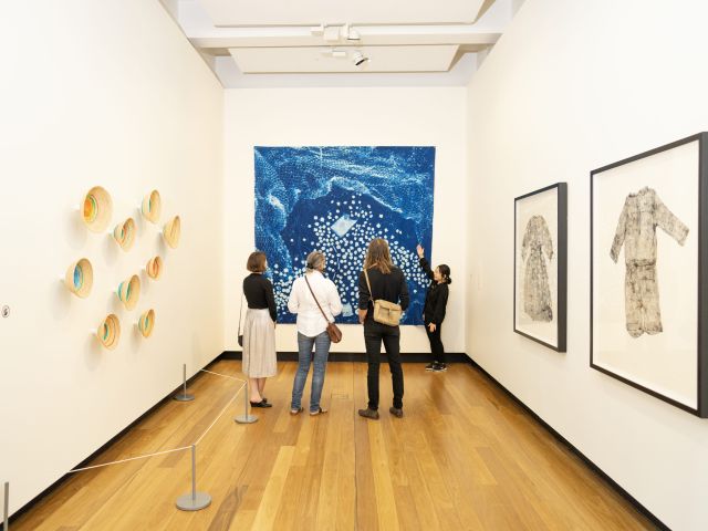 a family admiring artworks inside the Museum of Brisbane