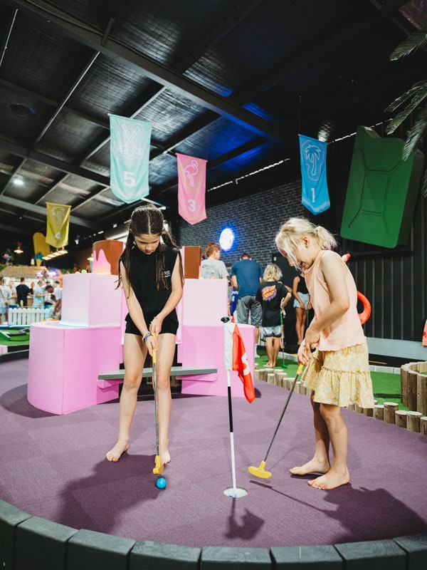 two kids playing golf at Hole in Fun