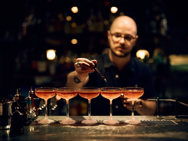 a bartender preparing drinks at Maybe Mae bar in Adelaide