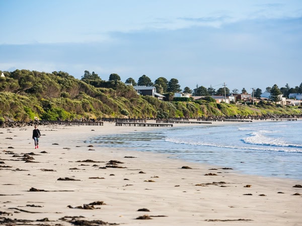 a woman walking on Port Fairy Beach