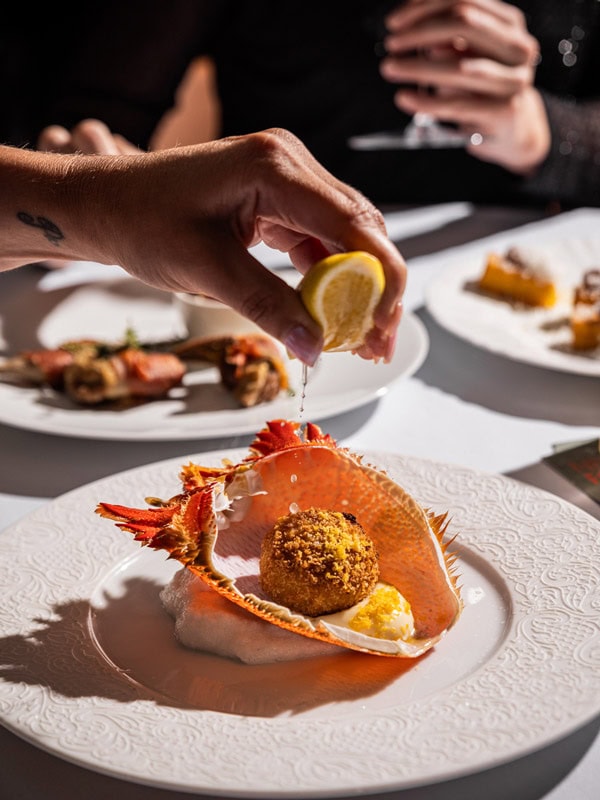 squeezing lemon into a dish at Gowings Bar & Grill, QT Sydney