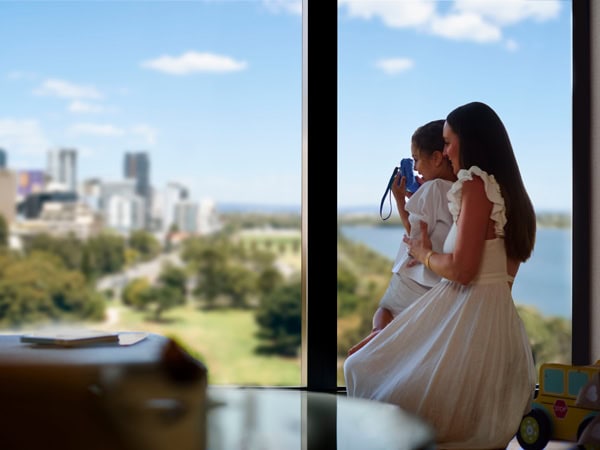 a woman with her child looking out the window at Ritz Carlton Perth 