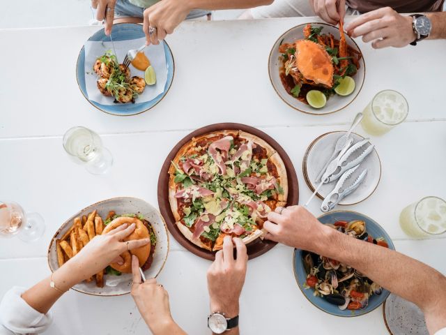hands reaching for food on the table at Margarita Daze, Umina