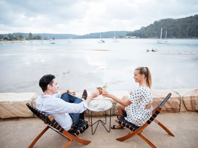 a couple enjoying evening drinks with a view at The BOX on the Water restaurant and bar, Ettalong Beach