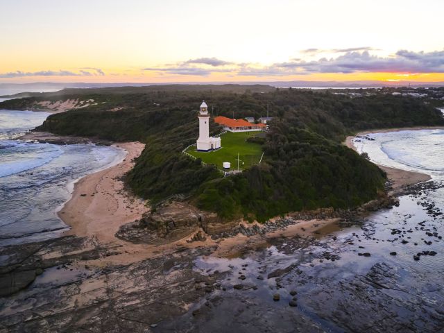 sun setting over Norah Head Lighthouse from above