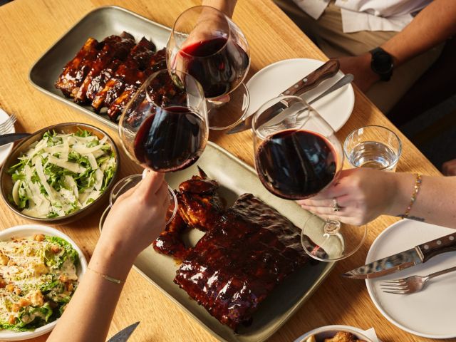 raising wine glasses over dinner at Hurricanes Grill & Bar Cronulla Beach