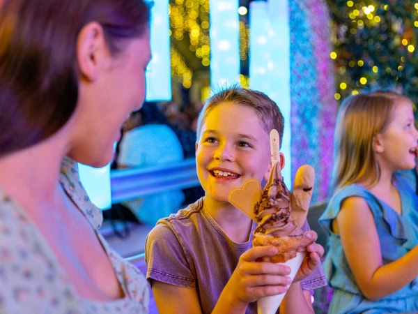 a kid smiling while holding a dessert at Eat Street Northshore