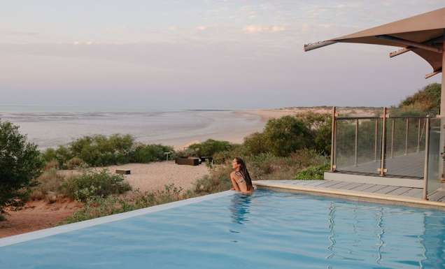 woman swims in the infinity pool at Eco Beach Resort Broome