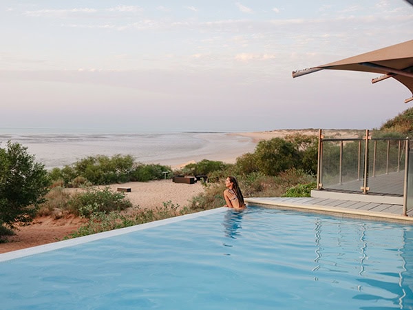 woman swims in the infinity pool at Eco Beach Resort Broome