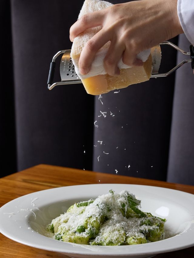 grating cheese on top of a dish at Persone Italian restaurant, Brisbane