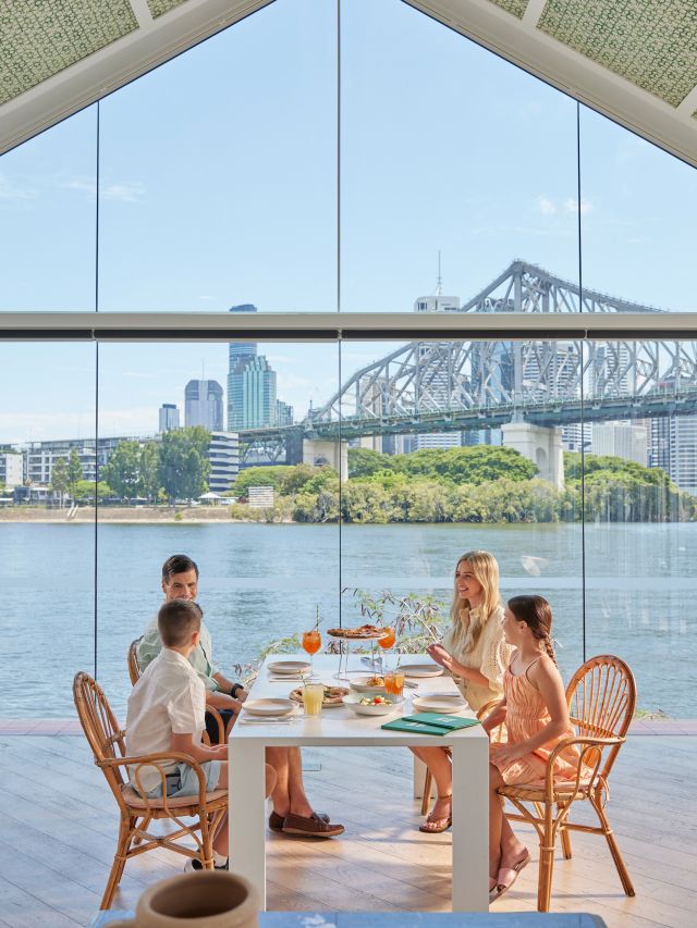 a family dining at Ciao Papi against the Brisbane River backdrop