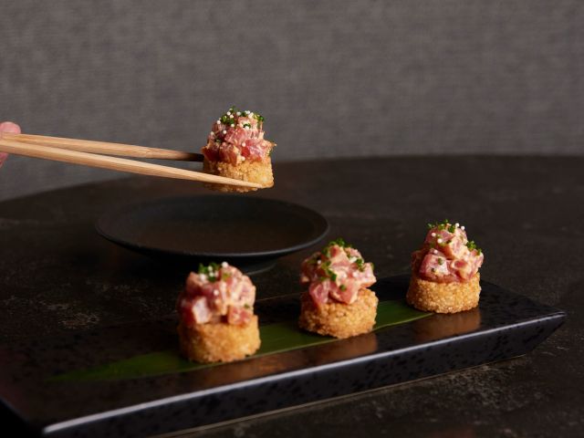 holding chopsticks with sushi at Sushi Room, Japanese restaurant Brisbane