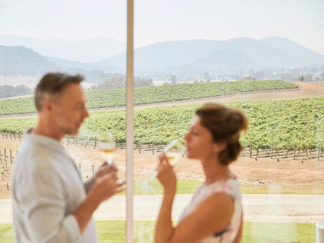 Couple enjoying wine with scenic views across Logan Wines vineyard in Apple Tree Flat near Mudgee.