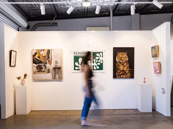 a blurry image of a woman walking into an exhibit at Mint Art House, Gold Coast