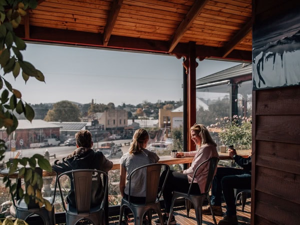 Friends gather on a balcony in the town of Omeo