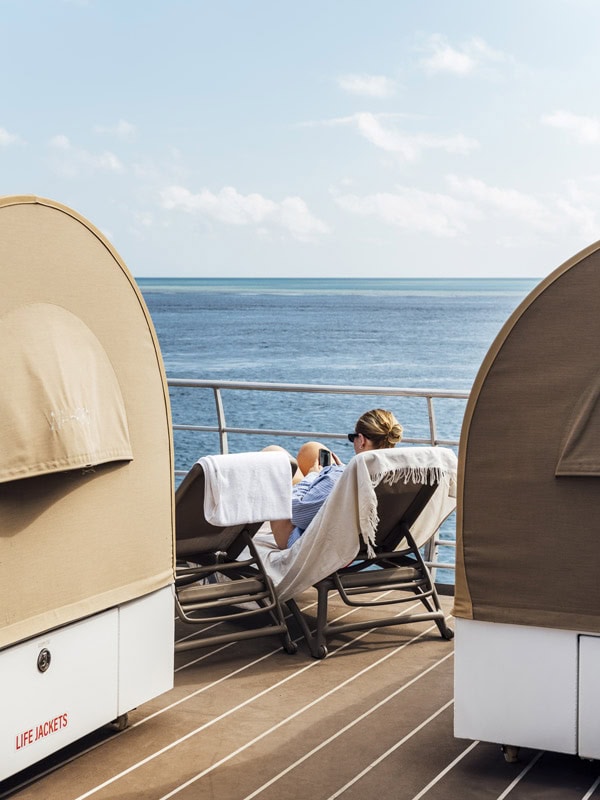 Woman resting next to Reefsleep bed 