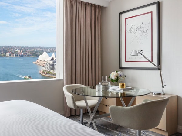 a dining table facing a window overlooking the Sydney Harbour