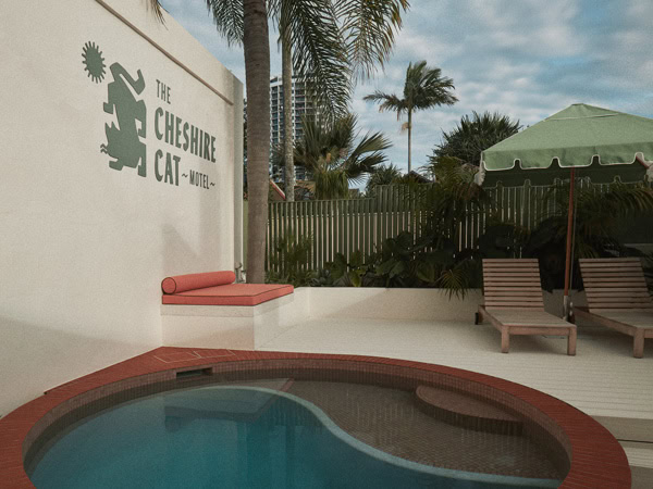 a pool with sun loungers at The Cheshire Cat Motel