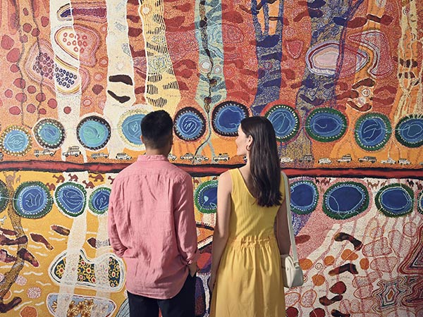 couple in front of indigenous art at WA Museum Boola Bardi