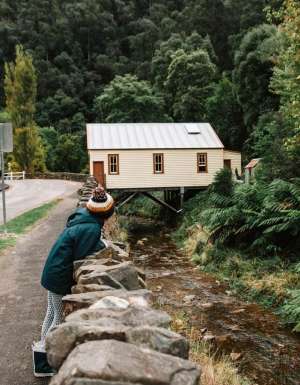 A woman on the edge of a road with Walhalla ghost town in the background