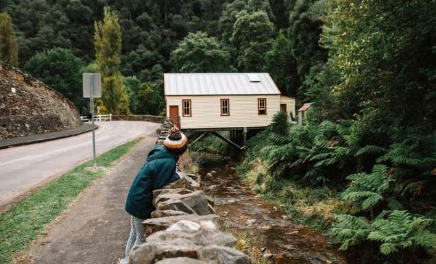 A woman on the edge of a road with Walhalla ghost town in the background