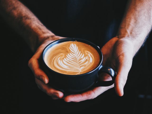 a hand holding a cup of coffee at Voodoo Cafe, Perth
