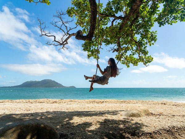 a girl relaxing in a swing on the beach at Fitzroy Island Resort
