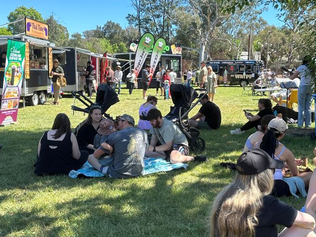 people sitting on the grass at Hartley Hall Markets