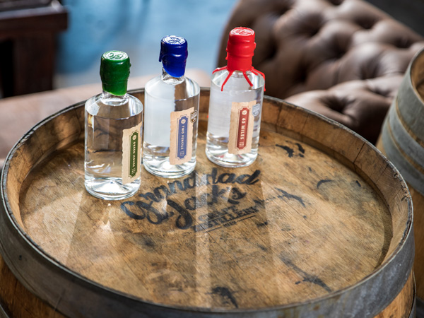 gin bottles on top of a wooden barrel at Grandad Jack’s, Miami, Gold Coast bars
