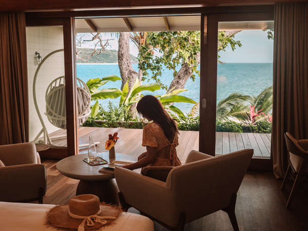 a woman relaxing in a luxe suite with sea views at Pelorus Private Island