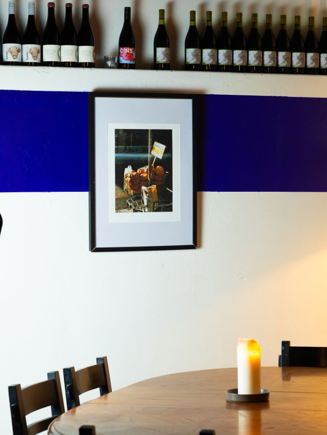 a dining table with wine bottles on top of the wall at Milquetoast, Brisbane