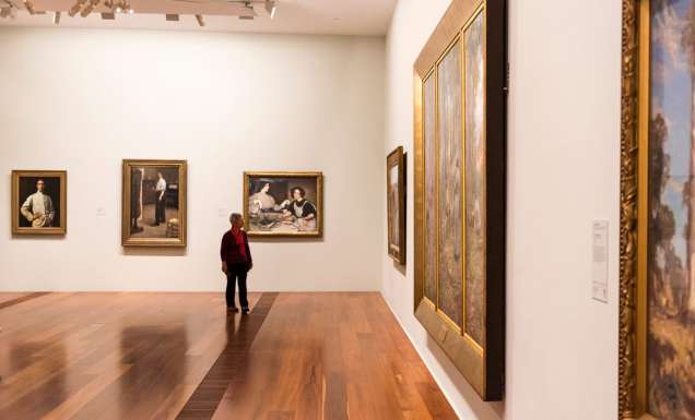 a man looking at artworks on the wall inside The Ian Potter Centre: NGV Australia, CBD