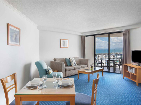 a spacious suite with a balcony with marina views at Mantra Hervey Bay