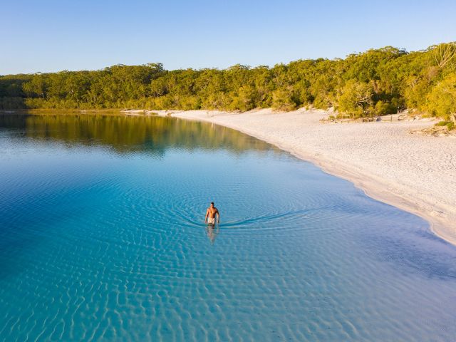man swimming in lake mckenzie on k'gari fraser island