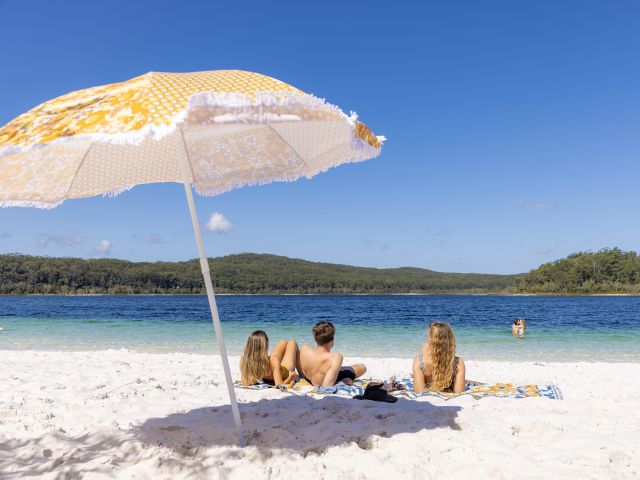 friends relax on the white sand at Lake McKenzie