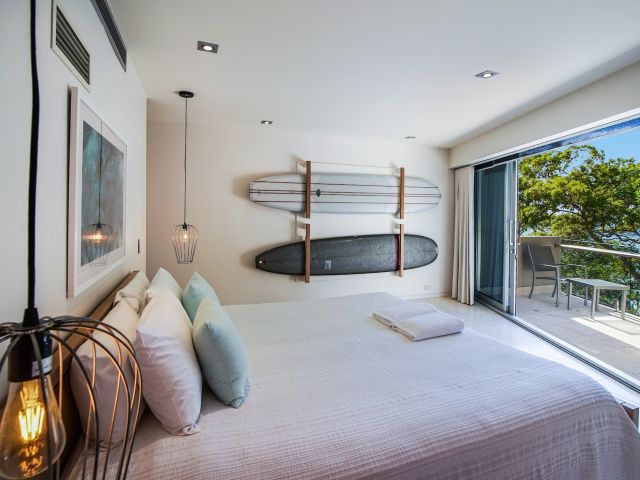 a bedroom with surfboards on the wall at Little Cove Court, Noosa