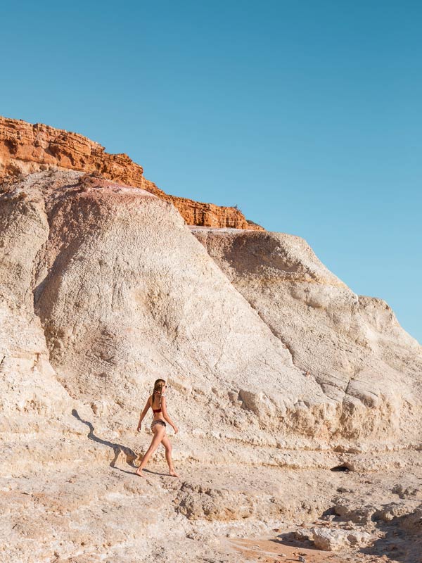 Woman climbs on the rocks at Port Noarlunga
