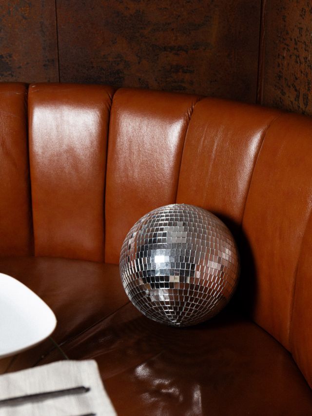 a silver disco ball on a leather seat at Bóveda, Wollongong