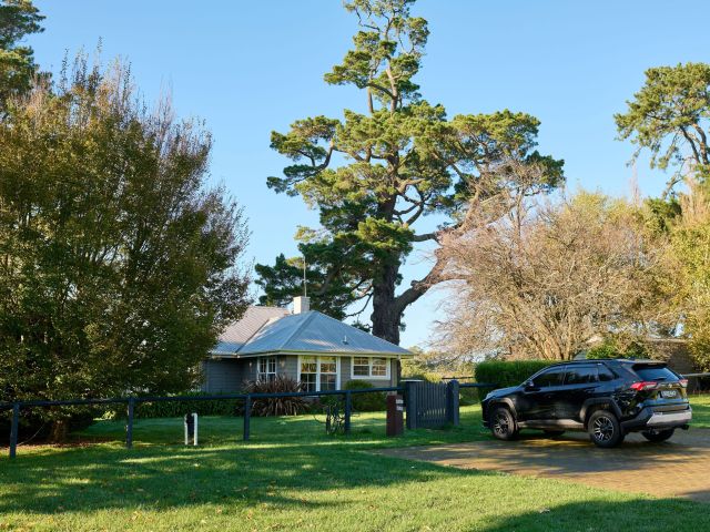 a black car parked outside the cottage at Bendooley Estate