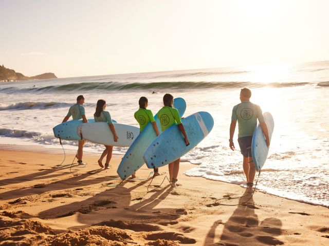 students of Central Coast Surf Academy heading out to surf