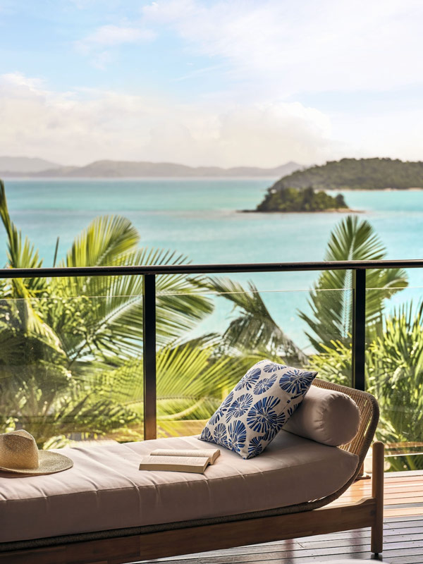 a daybed on the balcony with sea views at Hamilton Island Holiday Homes
