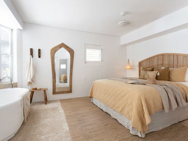 A neutral toned bedroom with a bath