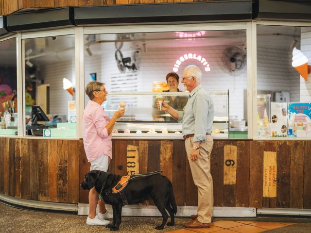 an old couple holding ice cream cones alongside their dog at The Ginger Factory, Noosa