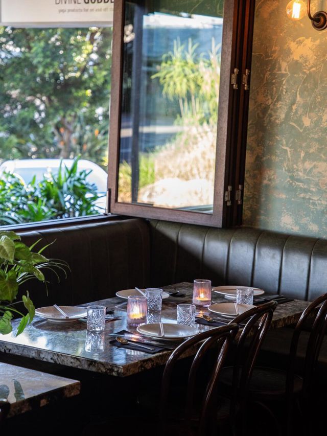a dining table next to a window at Bang Bang Noosa