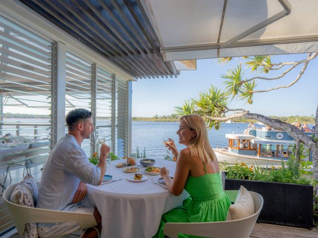 a couple dining by the Noosa River at Rickys River Bar & Restaurant 