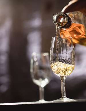 person pouring belgrove distillery whisky into a a glass of ice tasmania