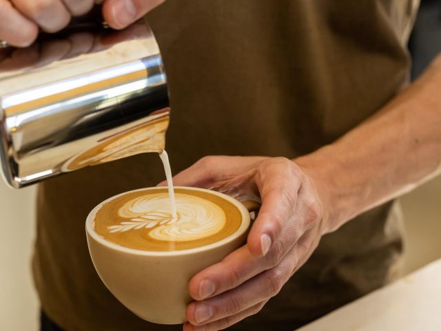 milk being poured into a cup of coffee at Meltdown, Braxton