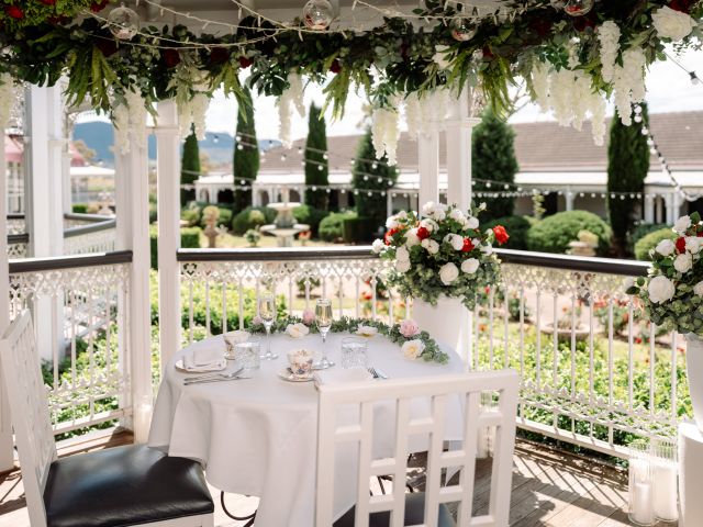 a dining area with floral arrangement at The Conservatory at voco Kirkton Park Hunter Valley